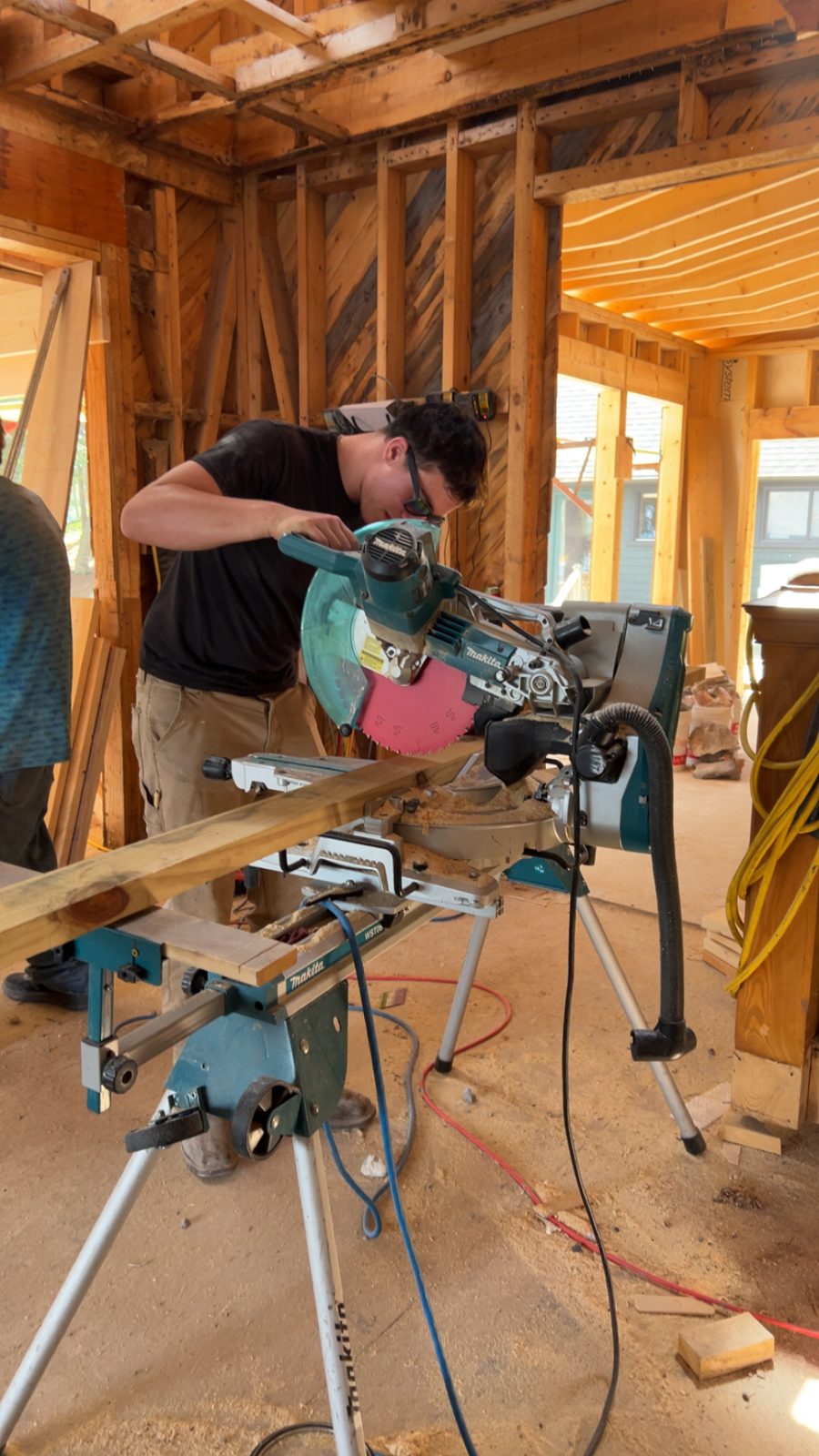 A Tupper Lake student cutting lumber on a miter saw